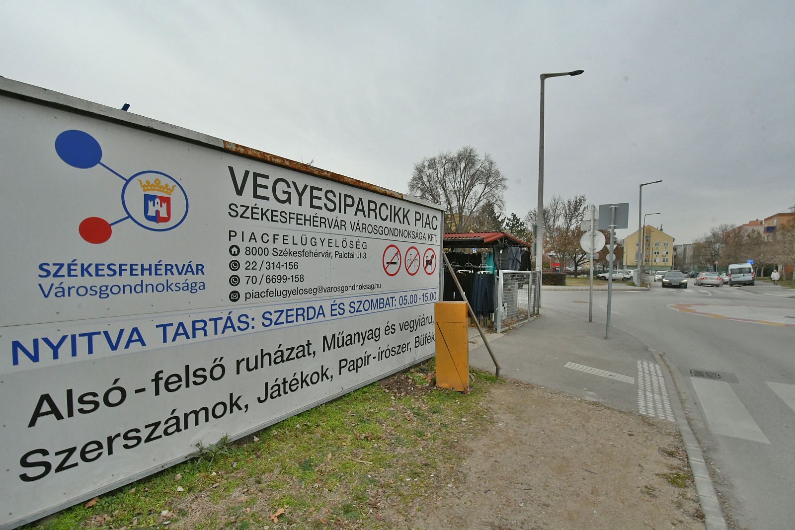 A képen az Iparcikk Piac bejáratánál lévő tájékoztató tábla látható, amin az elérhetőségek, nyitvatartás szerepel