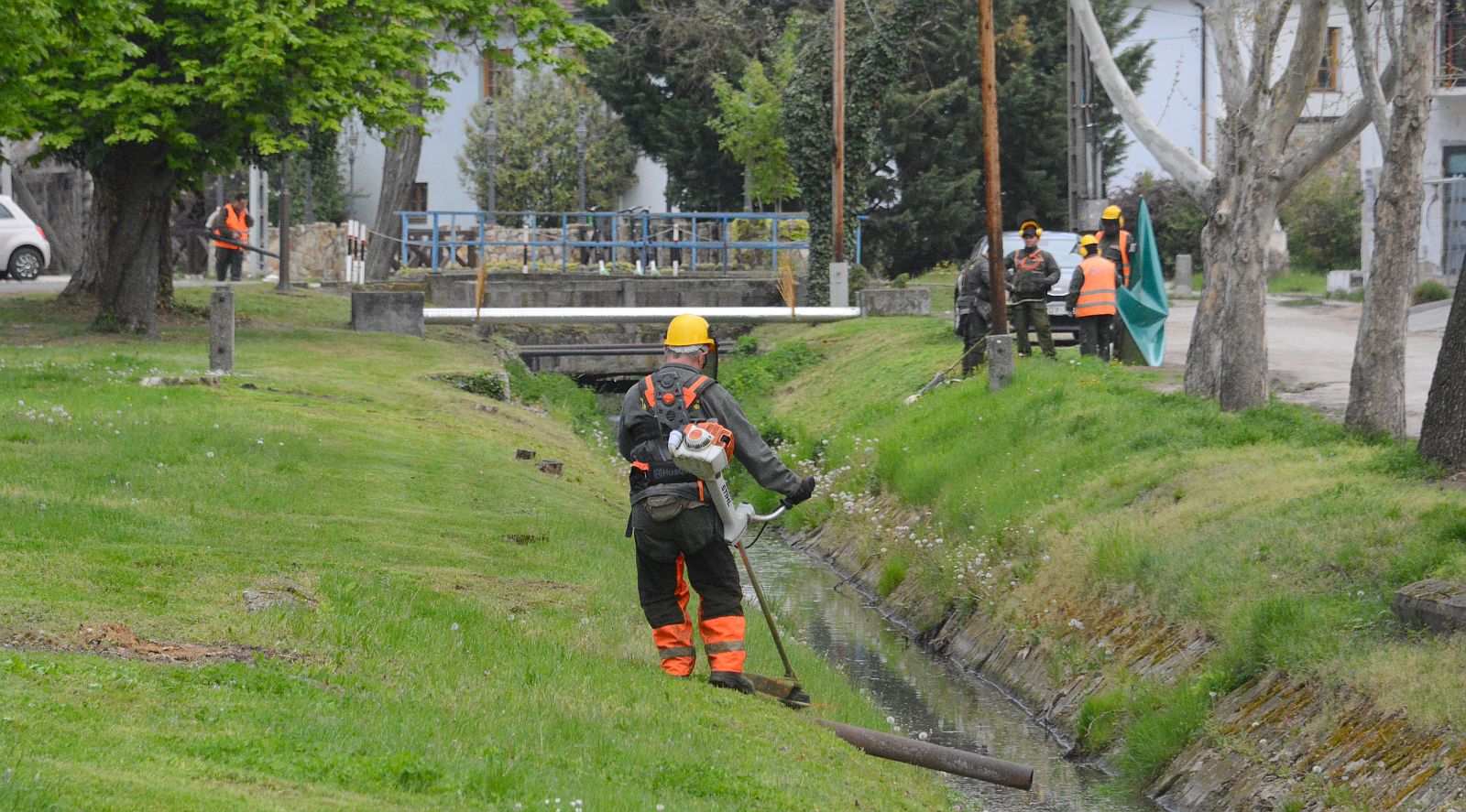 86 parkfenntartó munkatárs nyírja a füvet a városban